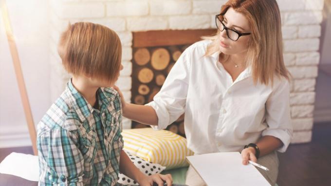 Pomogę Ci. Przyjemny profesjonalny psycholog rozmawiający ze szkolnym chłopcem i próbujący mu pomóc podczas sesji psychologicznej