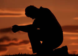 człowiek modlący się na jednym kolanie