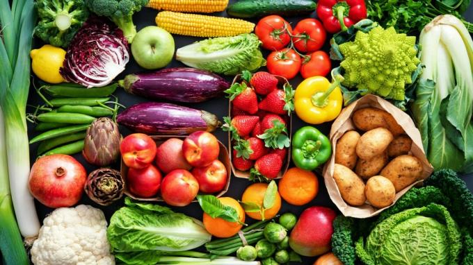 Tło żywności z asortymentem świeżych, zdrowych organicznych owoców i warzyw na stole